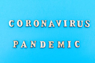 Slogan Coronavirus Salgını. Pastel mavi arka planda ahşap harflerle yapılmış. Coronavirus Pandemik Koruma Konsepti. Minimum konsept. Düz yatış, üst görünüm.