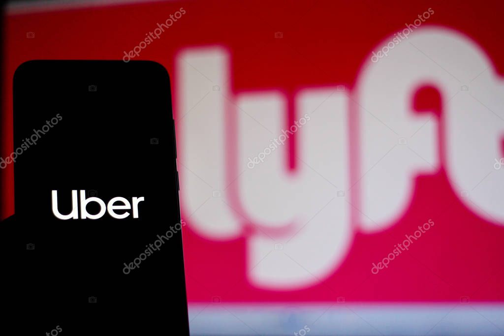 December 11, 2019. In this photo illustration the Uber logo is seen displayed on a smartphone and Lyft logo on the blurred background.
