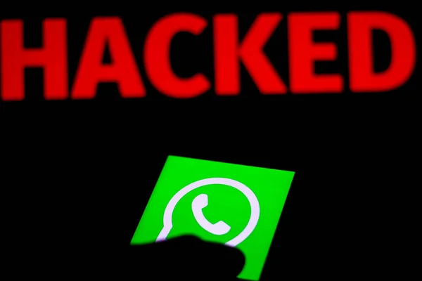 11 Desember 2019. Dalam gambar foto ini, logo Facebook WhatsApp ditampilkan pada smartphone dan kata peringatan merah Hacked pada latar belakang kabur. Foto konseptual untuk pelanggaran data — Stok Foto