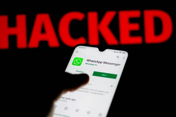 11 декабря 2019 года. На этой фотографии логотип Facebook WhatsApp отображается на смартфоне и красном тревожном слове Hacked на размытом фоне. Концептуальное фото для нарушения данных — стоковое фото