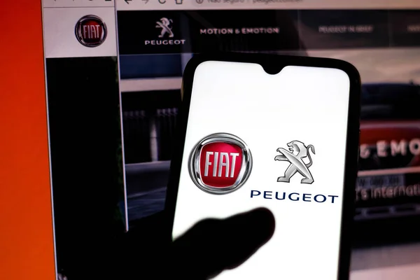 December 19, 2019, Brazil. In this photo illustration the FIAT Automobiles and Peugeot logo is displayed on a smartphone and opened websites on blurred background — Stock Photo, Image