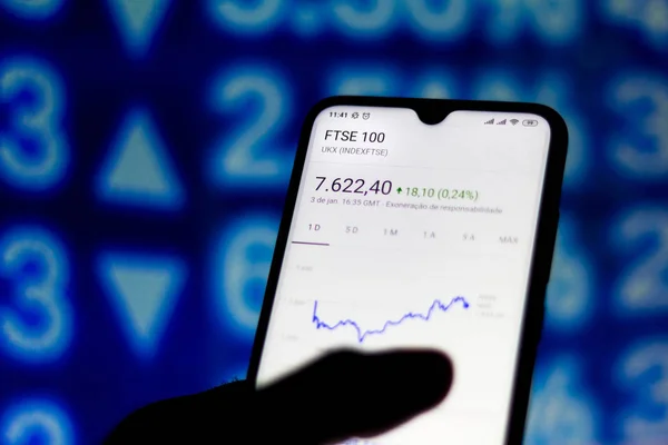 In this photo illustration the stock market data of the FTSE 100 is viewed on a smartphone — 스톡 사진