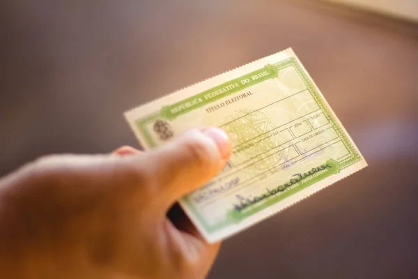 January 7, 2020, Brazil. Man holds the Voter License (Titulo Eleitoral). It is a document that proves that the person is able to vote in Brazil elections — Stock Photo, Image