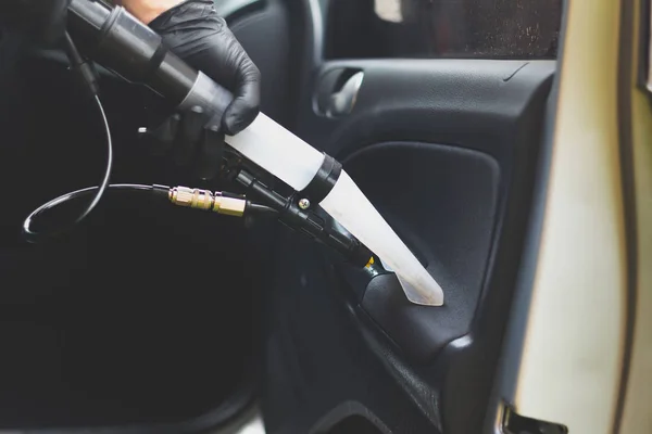 Man does car upholstery cleaning - Professional chemical cleaning with suction method. Hygienic work and stain removal on the vehicle seat