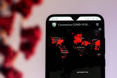 20 Mart 2020, Brezilya. Bu resimde bir etkileşimli harita akıllı telefon ekranında koronavirüs salgınının (Covid-19) vakalarını gösterir. Arka planda virüs görünüyor..