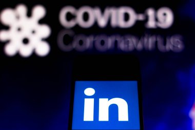 5 Nisan 2020, Brezilya. Bu resimde LinkedIn logosu, arka planda COVID-19 Coronavirus 'un bilgisayar modeli olan bir akıllı telefonda görüntülendi..