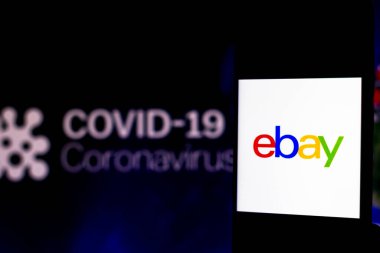 5 Nisan 2020, Brezilya. Bu resimde eBay logosu arka planda COVID-19 Coronavirus 'un bilgisayar modeli olan bir akıllı telefonda görüntülendi..