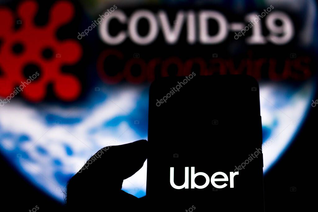 April 5, 2020, Brazil. In this photo illustration the Uber Technologies logo seen displayed on a smartphone with a computer model of the COVID-19 coronavirus in the background.