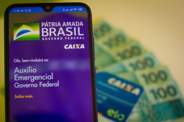 24 Nisan 2020, Brezilya. Bu resimde, Coronavirus sırasında devlet yardımı almak için yapılan Auxilio Emergencial da Caixa başvurusu akıllı telefondan görülür..