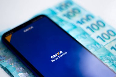 26 Nisan 2020, Brezilya. Bu resimde CAIXA uygulaması Bolsa Familia logosu akıllı telefondan görüntülenir.