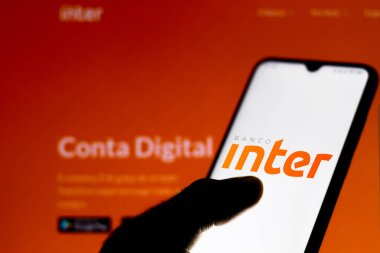 22 Mayıs 2020, Brezilya. Bu resimde Banco Inter logosu bankanın resmi web sitesinin bir bilgisayar modeliyle arka planda bir akıllı telefonda görüntülendi..