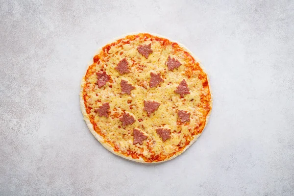 Pizza decorated with pepperoni shaped as Christmas trees. — Stock Photo, Image
