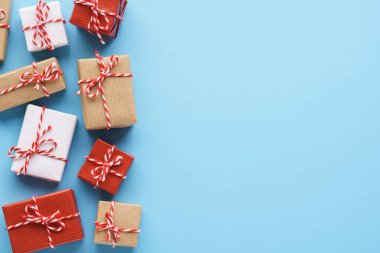 Açık mavi arkaplanda paketlenmiş hediye kutuları.
