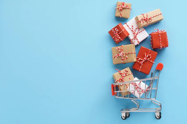 Cajas de regalo volando de un carrito de compras sobre fondo negro . — Foto de Stock