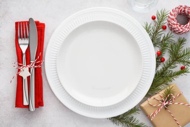 Tabaklar, kırmızı peçete, çatal ve bıçaklı Noel masası..