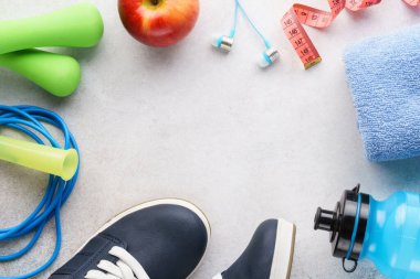 Spor ayakkabıları, su şişesi, dambıllar, havlu ve ip atlama. Spor malzemeleri. Sağlıklı yaşam tarzı kavramı. Boşluğu kopyala.