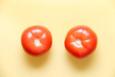 Sarı bir masada olgun kırmızı domates.