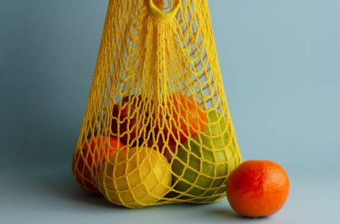 İp torbasında meyve. Sıfır atık. Mavi arkaplan