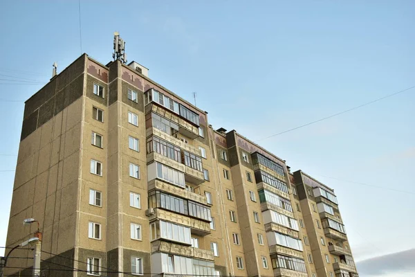 Gray residential buildings with antennas and wires.