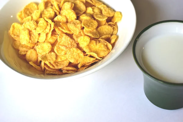 A Cup of yellow cornflakes in milk on a white background. Corn flakes, or cornflakes, is a breakfast cereal made by toasting flakes of corn (maize). The cereal was created by William Kellogg in 1894 for his brother John Kellogg. John Kellogg wanted a