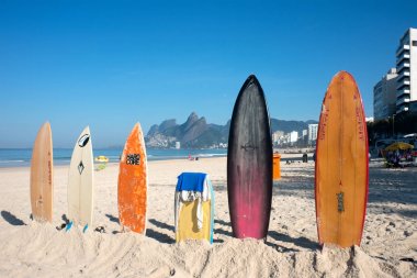 Ipanema Plajı üzerinde parlak güneşin altında dik duran sörf tahtaları