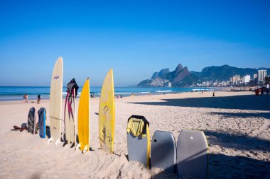 Ipanema Plajı üzerinde parlak güneşin altında dik duran sörf tahtaları, 