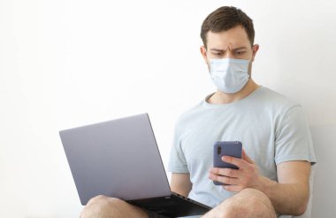 Coronavirus. Karantinaya alın. Bir adam iş ile ilgili soruları uzaktan çözer. Çevrimiçi eğitim, eğitim ve serbest çalışma. Bilgisayar, laptop. Dünyada koronavirüs salgını.