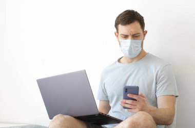 Coronavirus. Karantinaya alın. Bir adam iş ile ilgili soruları uzaktan çözer. Çevrimiçi eğitim, eğitim ve serbest çalışma. Bilgisayar, laptop. Dünyada koronavirüs salgını.