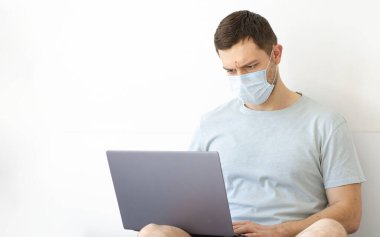 Coronavirus. Karantinaya alın. Bir adam iş ile ilgili soruları uzaktan çözer. Çevrimiçi eğitim, eğitim ve serbest çalışma. Bilgisayar, laptop. Dünyada koronavirüs salgını.