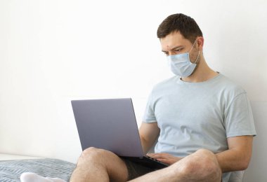 Coronavirus. Karantinaya alın. Bir adam iş ile ilgili soruları uzaktan çözer. Çevrimiçi eğitim, eğitim ve serbest çalışma. Bilgisayar, laptop. Dünyada koronavirüs salgını.