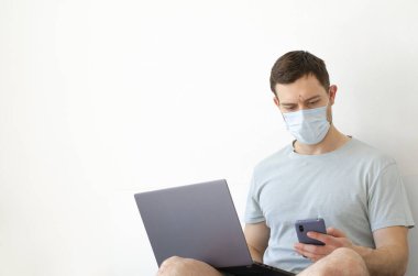 Coronavirus. Karantinaya alın. Bir adam iş ile ilgili soruları uzaktan çözer. Çevrimiçi eğitim, eğitim ve serbest çalışma. Bilgisayar, laptop. Dünyada koronavirüs salgını.