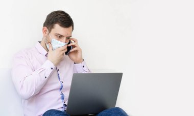Coronavirus. Karantinaya alın. Gömlekli ve kotlu bir adam iş sorunlarını uzaktan çözer. Maskeli olan. Belgeler. Laptop ve telefon. Dünyada koronavirüs salgını.