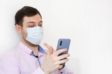 Coronavirus. Karantinaya alın. Koruyucu maskeli gömlekli bir adam. Bir video araması vasıtasıyla aileyle iletişim kurmak. Maske taktığını gösteriyor. Virüs koruması. Dünyada koronavirüs salgını.