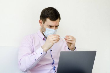 Coronavirus. Karantinaya alın. Gömlekli bir adam sıcaklığı ölçer. Yüksek ateş. Virüs koruması. Dünyada koronavirüs salgını.