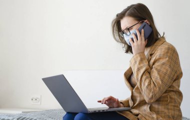 Coronavirus. Karantinaya alın. İş kadını iş sorunlarını uzaktan çözer. Laptop ve telefon. Virüs koruması. Dünyada koronavirüs salgını.