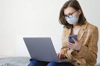 Coronavirus. Karantinaya alın. İş kadını iş sorunlarını uzaktan çözer. Laptop ve telefon. Virüs koruması. Dünyada koronavirüs salgını.