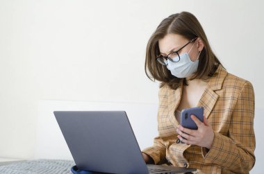 Coronavirus. Karantinaya alın. İş kadını iş sorunlarını uzaktan çözer. Laptop ve telefon. Virüs koruması. Dünyada koronavirüs salgını.