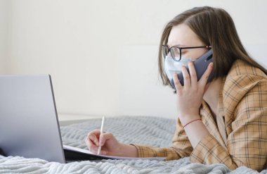Coronavirus. Karantinaya alın. İş kadını iş sorunlarını uzaktan çözer. Belgeler. Laptop ve telefon. Virüs koruması. Dünyada koronavirüs salgını.