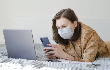 Coronavirus. Karantinaya alın. İş kadını iş sorunlarını uzaktan çözer. Laptop ve telefon.