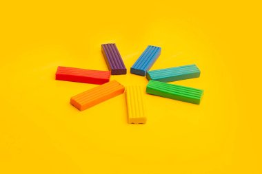 Gökkuşağı renklerinin plastiği güneş şeklinde sarı bir zemin üzerine serilmiştir.