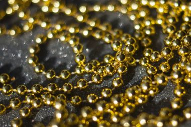 Siyah arkaplanda altın boncuklar.