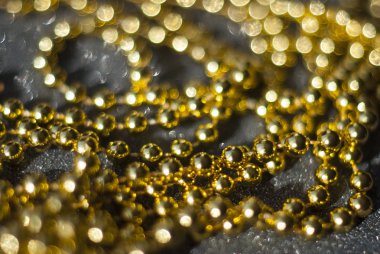 Siyah arkaplanda altın boncuklar.