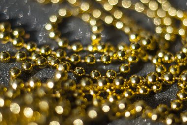 Siyah arkaplanda altın boncuklar.