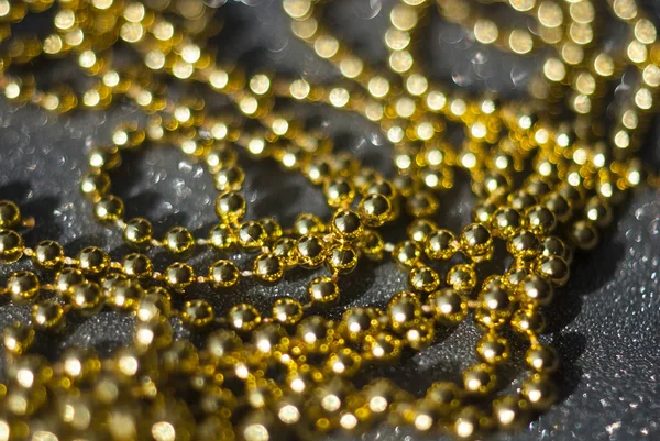 Siyah arkaplanda altın boncuklar.