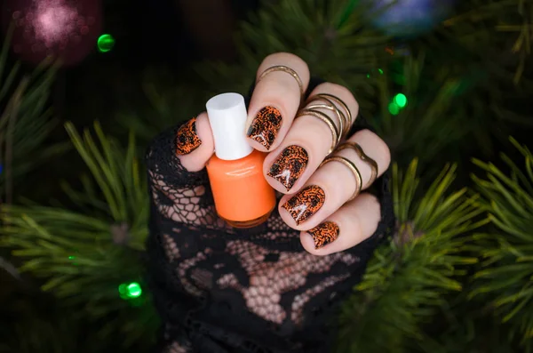 Manikűr nail art design új évre, fekete csillogó körmök narancs köröm művészet a háttér a karácsonyfa — Stock Fotó