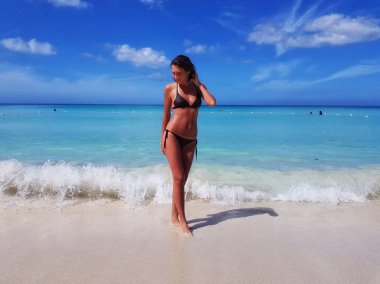 Karayip Denizi kıyısında plajda güneşlenirken bikinili genç kız