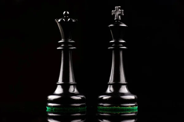 Kahverengi ve beyaz satranç tahtasında satranç saati olan siyah ve beyaz plastik satranç taşları.