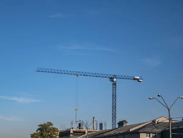 Grúa de construcción sobre un fondo de cielo azul . — Foto de Stock
