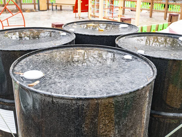 Black iron industrial barrels for liquids.