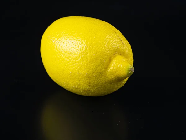 Żółty owoc cytryny na czarnym tle z miejscem na tekst. — Zdjęcie stockowe